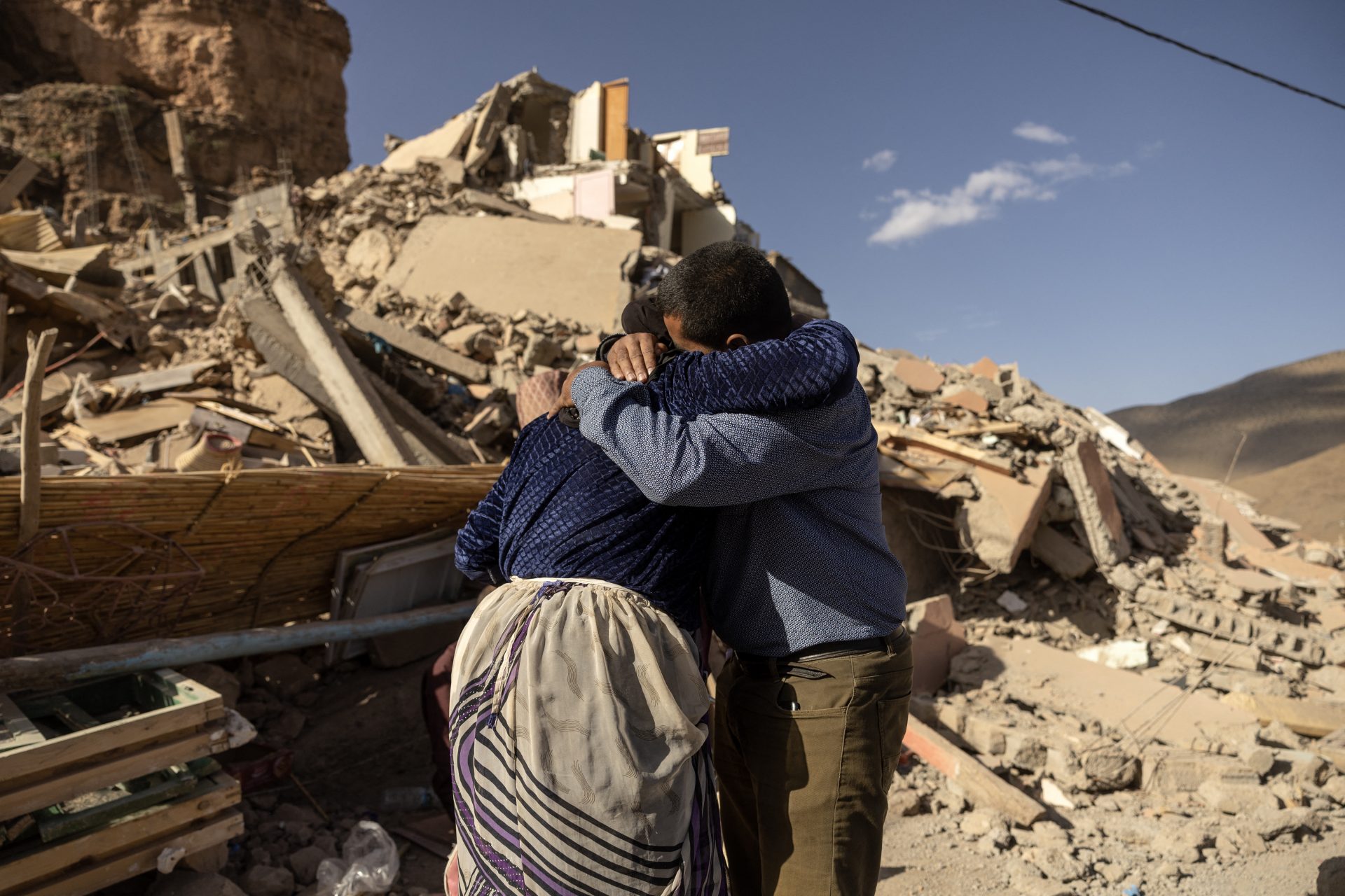 Familiemedlemmer krammer hinanden nær ruinerne af deres hjem i landsbyen Imi N'Tala i det centrale Marokko. FOTO: Fadel Senna/AFP